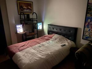 een slaapkamer met een bed in een kamer met 2 televisies bij Hermosa Suite para largas estadías con parqueadero in Quito