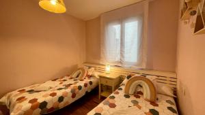 two twin beds in a small room with a window at B32 - El Refugio de Benasque - Villmor in Benasque