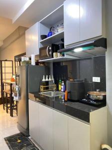 uma cozinha com um frigorífico e uma bancada em Staycation in Quezon City with Netflix and Pool access at Tranquil Space by Ada em Manila