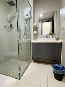 a bathroom with a glass shower and a sink at Green Haven 1 Bedroom in Masai