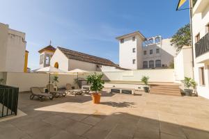 a courtyard of a building with chairs and tables at Pilar8 - Apartamento céntrico y moderno con piscina y parking in Jaén