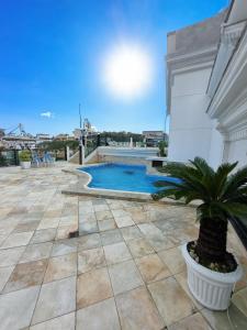 a swimming pool on a patio with a potted plant at Loft Frente ao Mar com Piscina Aquecida, Sauna Privada - Arraial do Cabo in Arraial do Cabo +17 photos