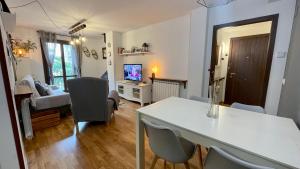 a living room with a table and chairs and a television at B32 - El Refugio de Benasque - Villmor in Benasque