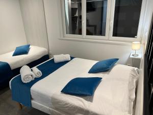 Face à la mer في جرافيلين: غرفة نوم بسريرين مع وسائد زرقاء وبيضاء