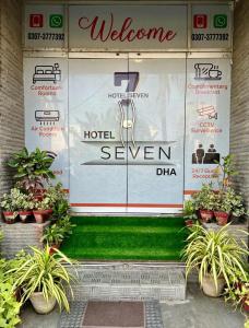 a store front with a welcome sign and plants at Hotel 7 DHA in Karachi
