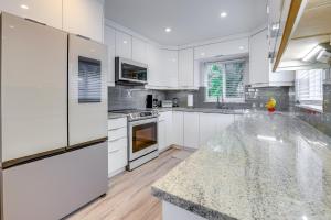 a kitchen with white cabinets and a marble counter top at 2 Blocks to Riviera Beach Upscale Condo with Patio in West Palm Beach