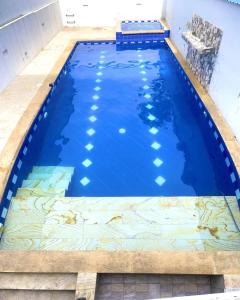 una gran piscina azul con suelo de baldosa en Hotel Tradicional Villeta, en Villeta