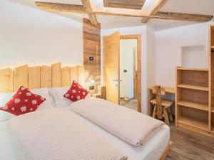ein Schlafzimmer mit einem großen weißen Bett mit roten Kissen in der Unterkunft CESA MARIN in Campitello di Fassa