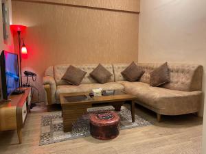 a living room with a couch and a coffee table at Al-Rabie Hotel & Apartments in Baghdād