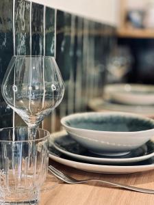 a wine glass sitting on a table with plates and bowls at Le Chalet de la Plage in Sévrier