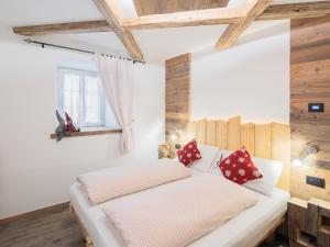 Schlafzimmer mit einem weißen Bett und roten Kissen in der Unterkunft CESA MARIN in Campitello di Fassa