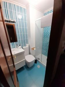 a bathroom with a white toilet and a sink at Apartamento pleno centro Ferrol. in Ferrol