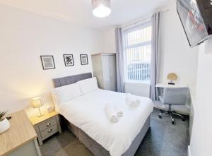 a bedroom with a bed and a desk and a window at Burnley Terraced House by BEVOLVE - Free Parking 2 in Burnley