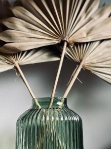 a green vase with sticks sticking out of it at Le Chalet de la Plage in Sévrier