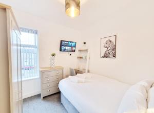 a bedroom with two beds and a tv and a window at Burnley Terraced House by BEVOLVE - Free Parking 2 in Burnley
