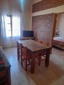 ein Esszimmer mit einem Holztisch und Stühlen in der Unterkunft cabañas oliv- san rafael-mendoza in San Rafael