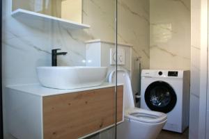 a bathroom with a sink and a washing machine at Apartment Terezija in Dubrovnik