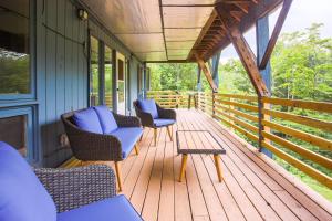 a porch with chairs and a table on a house at Stark Mountain Sanctuary in Waitsfield