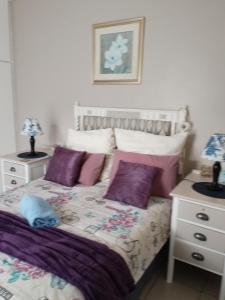 Sunridge ParkにあるSan-Lou Airbnbのベッドルーム(紫色の枕が付くベッド付)
