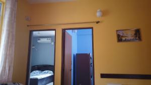 een kamer met 2 glazen deuren en een spiegel bij Yago's Hideout in Bogmalo