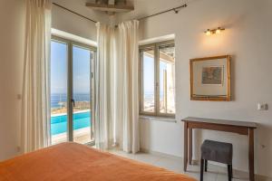 a bedroom with a bed and a view of the ocean at PHAEDRA, Luxury Villa Private Infinity Pool Sea View Stoupa in Exochori