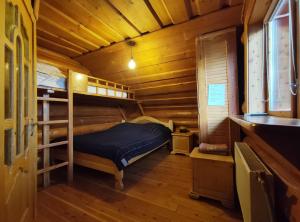 ein Schlafzimmer mit Etagenbetten in einer Holzhütte in der Unterkunft Дерев'яний котедж "Казка" in Jaremtsche