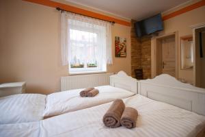 2 camas con toallas en un dormitorio en Penzion Anebel en Luhačovice