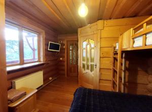 a bedroom in a log cabin with a bed and a window at Дерев'яний котедж "Казка" in Yaremche