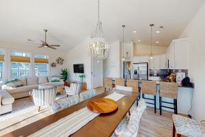 een keuken en een woonkamer met een tafel en stoelen bij Saylor’s Sandcastle in Surf City
