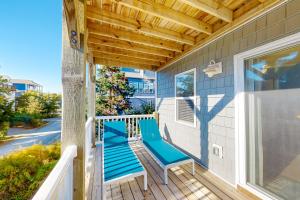 een veranda met blauwe banken op een huis bij Saylor’s Sandcastle in Surf City