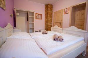 1 dormitorio con 2 camas y zapatillas en Penzion Anebel en Luhačovice