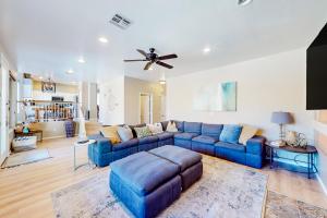 a living room with a blue couch and a ceiling fan at Villa in the Sun in Phoenix