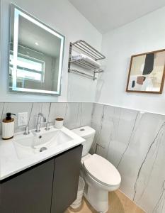 a white bathroom with a toilet and a sink at High-End Apartment, Across the Beach in Miami Beach