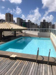 a swimming pool on the roof of a building at Amplo Quarto e sala decorado in Salvador