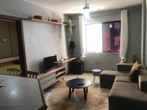 a living room with a couch and a tv at Amplo Quarto e sala decorado in Salvador