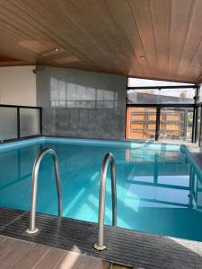 una gran piscina con dos barras metálicas. en Santa Catarina Plaza Hotel, en Canoinhas