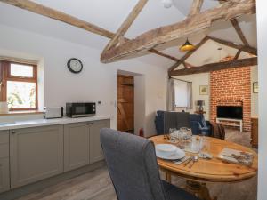 a kitchen and dining room with a wooden table and chairs at Keepers Barn in Worcester