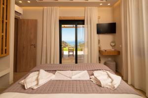 a bedroom with a bed with a view of the ocean at Aoria Villas in Palaiochóra