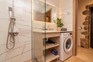 a bathroom with a shower and a washing machine at Aoria Villas in Palaiochóra