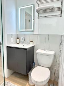 a bathroom with a toilet and a sink and a mirror at High-End Apartment, Across the Beach in Miami Beach