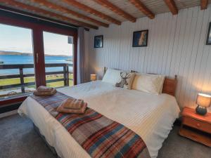 a bedroom with a bed with a view of the water at Doune Bay Lodge in Mallaig
