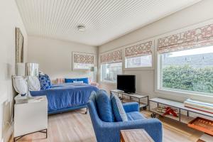a bedroom with a bed and two chairs and a tv at Cannon Beach Saltbox Cottage in Cannon Beach