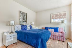 a bedroom with a bed and a chair at Cannon Beach Saltbox Cottage in Cannon Beach