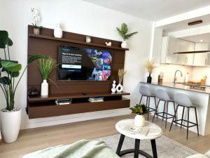 a living room with a tv and a kitchen at High-End Apartment, Across the Beach in Miami Beach