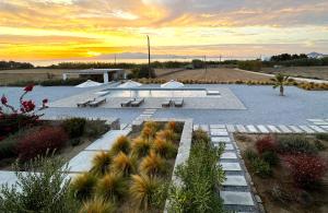 a park with benches and a sunset in the desert at Archon Seaside Retreat in Plaka