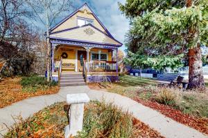 una piccola casa gialla con portico e marciapiede di Old Town Victorian a Steamboat Springs