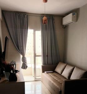 uma sala de estar com um sofá em frente a uma janela em Apto c/ Ar Wifi Suite Garagem Shopping em Taubaté