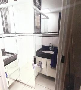 uma casa de banho com 2 lavatórios e uma cabina de duche em vidro. em Apto c/ Ar Wifi Suite Garagem Shopping em Taubaté