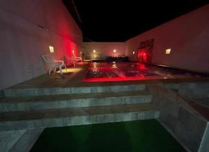 a room with a swimming pool at night with red lights at Hotel Tradicional Villeta in Villeta