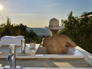 a man wearing a hat sitting in a bath tub at Éco Spa Highland in Grenville-sur-la-Rouge